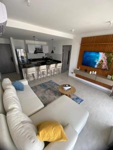 a living room with a white couch and a kitchen at Golden Breeze in Cartagena de Indias