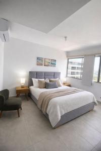 a bedroom with a large bed and a chair at Golden Breeze in Cartagena de Indias +23 photos