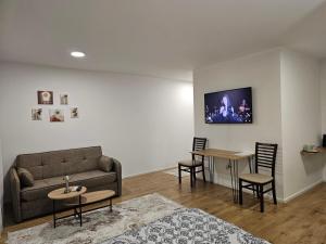 a living room with a couch and a table and chairs at River stone studio in Prizren