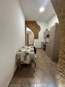 a room with a table and a kitchen at Kalgheros in Agrigento