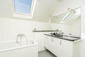 a white bathroom with a sink and a tub at 272-Ringkobing-Vestklitvej-22 in Klegod +18 photos