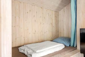 a small room with a bed in a wooden wall at 160-Ringkobing-Granalle-17 in Nørby