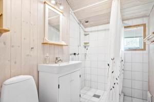 a white bathroom with a sink and a toilet at 160-Ringkobing-Granalle-17 in Nørby +18 photos