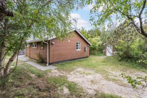 a small red brick house in the middle of a yard at 160-Ringkobing-Granalle-17 in Nørby