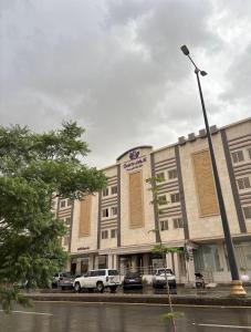 a large building with cars parked in front of it at Quartz Executive - كوارتز التنفيذية in Abha