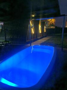 a blue pool in a backyard at night at 2204 Chácara Pousada CadClub Quarto Suíte Para Casal in Sao Jose do Rio Preto