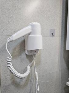 a white phone is hanging on a wall at River stone studio in Prizren +5 photos