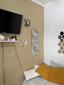 a bedroom with a tv on the wall and a bed at Apto completo,1 dorm, pé na areia na Cidade Praia Grande, praia mirim in Praia Grande