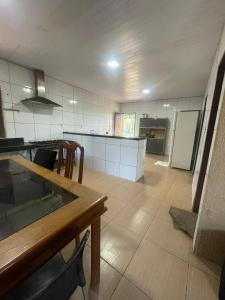 a large kitchen with a table and a counter top at Sitio Resenha in Caucaia