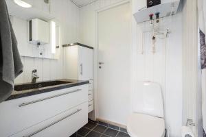 a white bathroom with a toilet and a sink at 208-Ringkobing-Fladsbjergvej-226 in Klegod +38 photos
