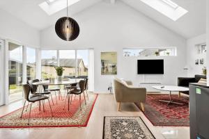 a living room with a table and chairs and a tv at 1130-Ringkobing-Sletten-18 in Søndervig