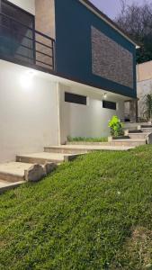 a house with a blue and white wall and some grass at Cerro Escondido in Chiapa de Corzo