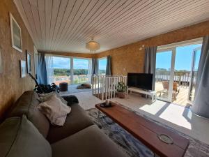 a living room with a couch and a flat screen tv at Newly-built villa in a perfect location! in Grebbestad