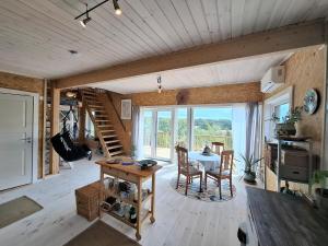 a living room with a table and chairs and a staircase at Newly-built villa in a perfect location! in Grebbestad