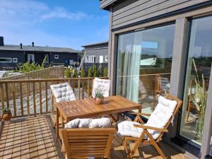 a patio with a wooden table and chairs on a balcony at Newly-built villa in a perfect location! in Grebbestad