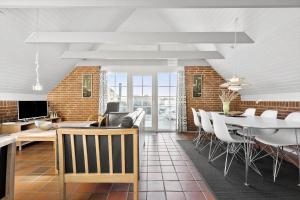 a dining room and living room with a table and chairs at 290-Ringkobing-Nordso-Ferievej-50 in Nørre Lyngvig