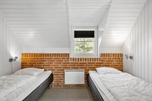 two beds in a room with a brick wall at 290-Ringkobing-Nordso-Ferievej-50 in Nørre Lyngvig