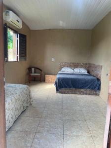 a bedroom with two beds and a table and a window at Sitio Resenha in Caucaia