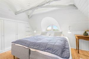 a white bedroom with a bed and a window at 1154-Ringkobing-Nordsovej-50 in Søndervig