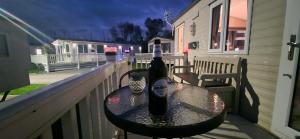 a bottle of wine sitting on a table on a balcony at Bewles Caravan in Rhyl