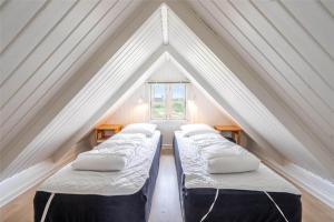 three beds in a attic with a window at 207-Ringkobing-Nordso-Ferievej-27 in Nørre Lyngvig