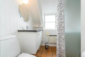 a bathroom with a toilet and a sink and a mirror at 207-Ringkobing-Nordso-Ferievej-27 in Nørre Lyngvig +30 photos