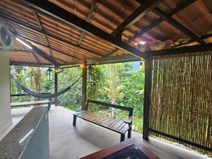 a porch with a hammock in a house at Green Area House in Abraão