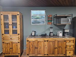 a kitchen with wooden cabinets and a counter top at Green Area House in Abraão