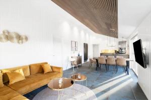 a living room with a couch and tables and a kitchen at 1157-Ringkobing-Frans-Julius-Vej-7 in Klegod