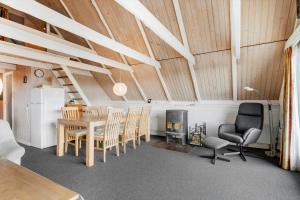 a living room with a table and chairs and a fireplace at 2254-Ringkobing-Nordso-Ferievej-52 in Nørre Lyngvig