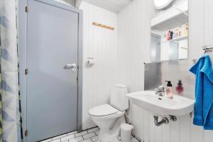a white bathroom with a toilet and a sink at 2254-Ringkobing-Nordso-Ferievej-52 in Nørre Lyngvig +27 photos