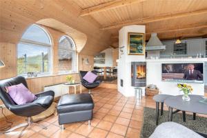 a living room with a fireplace and a table and chairs at 152-Ringkobing-Regnspovedalen-6 in Nørby