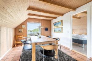 a dining room with a table and chairs and a bed at 152-Ringkobing-Regnspovedalen-6 in Nørby