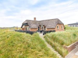 a house on top of a grassy hill at 152-Ringkobing-Regnspovedalen-6 in Nørby
