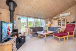 a living room with a couch and a tv at 078-Ringkobing-Rorsangervej-11 in Nørby