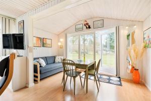 a living room with a table and a couch at 095-Ringkobing-Risbjergvej-12 in Nørby