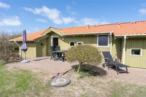 a house with a picnic table and an umbrella at 078-Ringkobing-Rorsangervej-11 in Nørby