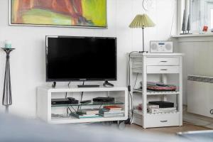 a television on a white stand in a living room at 235-Ringkobing-Vestklitvej-11 in Klegod