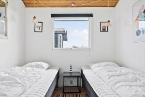 two beds in a room with a window at 235-Ringkobing-Vestklitvej-11 in Klegod