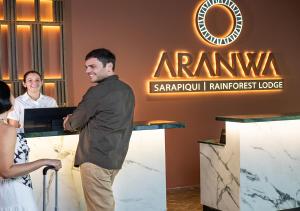 a man standing at a counter in front of a sign at Aranwa Sarapiquí Rainforest Lodge in Sarapiquí