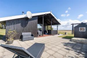 a pavilion with a couch and chairs on a patio at 265-Ringkobing-Klitsvinget-5 in Klegod