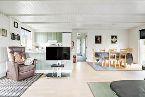 a living room with a television and a dining room at 265-Ringkobing-Klitsvinget-5 in Klegod
