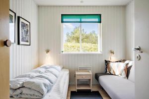 a bedroom with a bed and a window at 265-Ringkobing-Klitsvinget-5 in Klegod