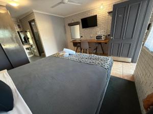a bedroom with a bed and a kitchen with a table at Surf Beach Motel Tweed in Tweed Heads +30 photos