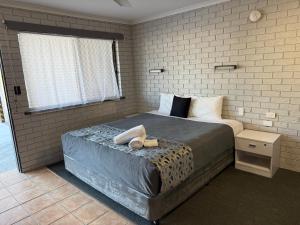 a bedroom with a bed with a pair of shoes on it at Surf Beach Motel Tweed in Tweed Heads