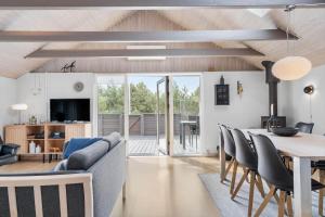 a dining room and living room with a table and chairs at 1103-Ringkobing-Frans-Julius-Vej-17 in Klegod