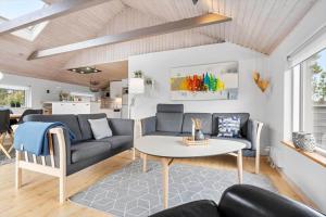 a living room with a couch and a table at 1103-Ringkobing-Frans-Julius-Vej-17 in Klegod +25 photos