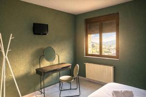 a bedroom with a desk and a bed and a window at Coronel Somiedo by Unusual Hotels in El Puerto de Somiedo
