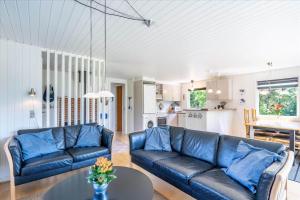 a living room with a blue couch and a table at 233-Ringkobing-Milevej-38 in Klegod +17 photos