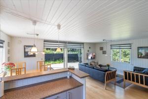 a kitchen and living room with a couch and a table at 233-Ringkobing-Milevej-38 in Klegod